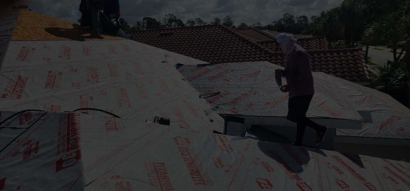 Roofer installing underlayment on residential property