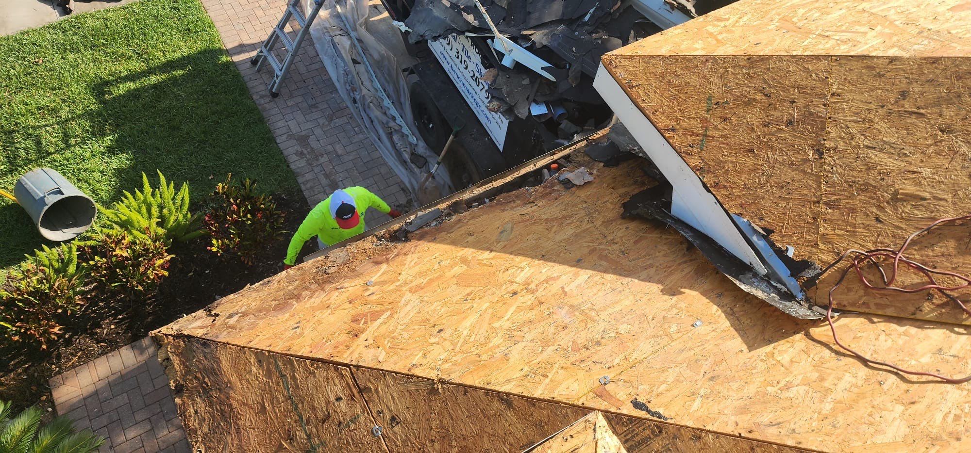 Plywood roof deck installation worker aerial view