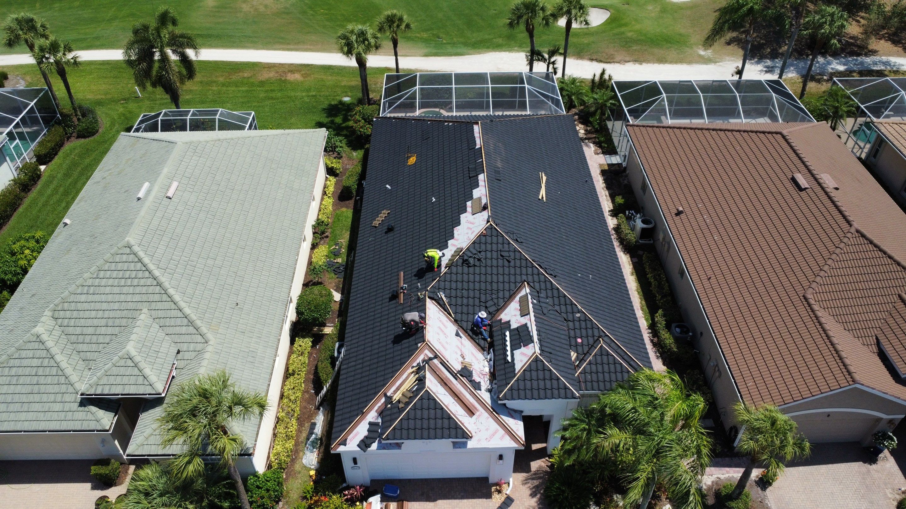 Aerial view of workers installing mixed color tile roof