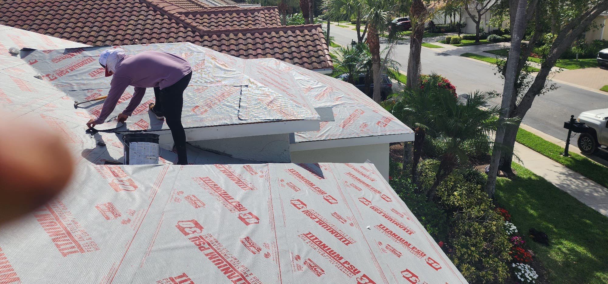 Professional roofer installing underlayment on residential property